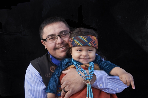 A photo of a young Navajo man and his child.