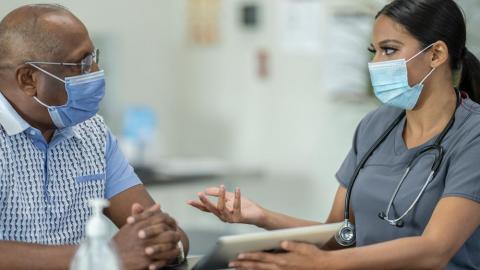 A doctor talking to a patient about COVID-19 vaccination.