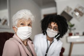 A photo of an older woman and her doctor.