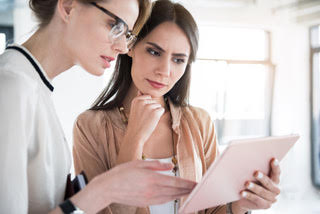 A photo of 2 case managers reviewing a patient's chart.