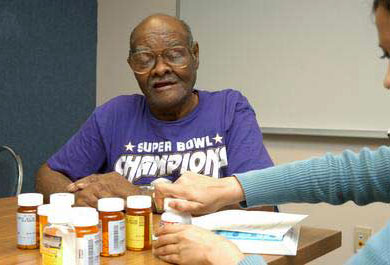 A photo of an older man on multiple medications participating in a medication review. 