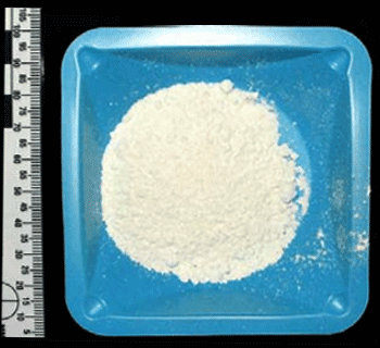 A photograph of a sample of a white powder identified as mephedrone.