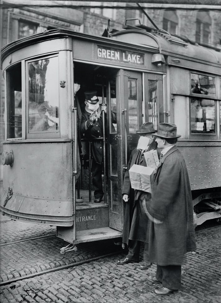 A photo from the 1918 flu pandemic with a trolley conductor refusing entry to a man not wearing a mask.
