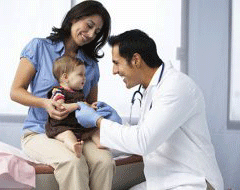 Image: A toddler being examined by a pediatrician