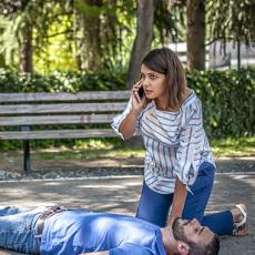 A man who has overdosed being helped by a friend.