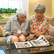 A photo of 2 women looking at personal photos.