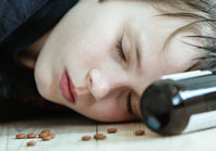 Young woman beside pill bottle.