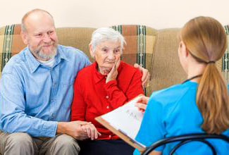Photograph of a man with his elderly mother talking to a nurse.